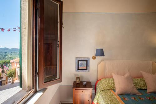 Un dormitorio con una cama y una ventana con vistas. en CuccurucuMare- suite apartment, en Castagneto Carducci
