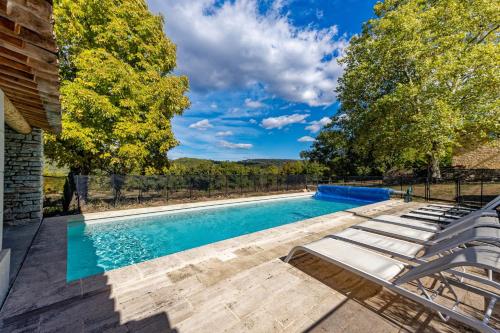 a swimming pool with lounge chairs next to a house at Villa spacieuse avec jardin à Saignon in Saignon