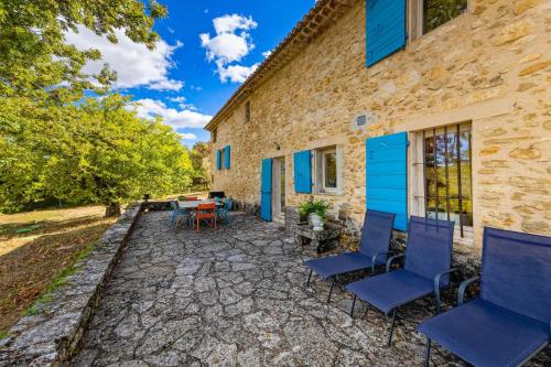 a patio with chairs and a table next to a building at Villa spacieuse avec jardin à Saignon in Saignon