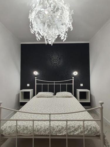 1 dormitorio con 1 cama con una lámpara de araña grande en Natura Park en Jastrzębia Góra