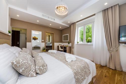 a bedroom with a large white bed with pillows at Peninsula Luxury Suite in Zadar