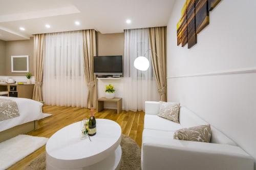 a living room with a white couch and a tv at Peninsula Luxury Suite in Zadar
