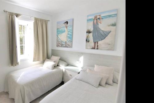 a bedroom with two beds and paintings on the wall at 2 bedrooms appartement with wifi at San Cristobal de La Laguna in Las Lagunas