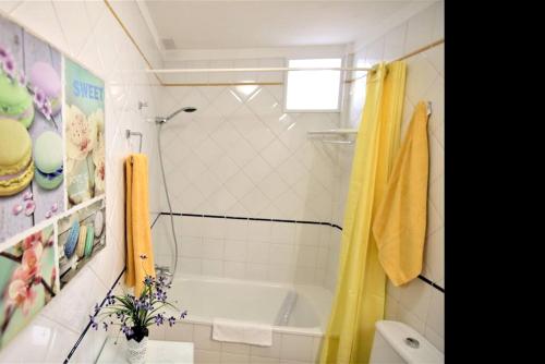 a bathroom with a tub and a yellow shower curtain at 2 bedrooms appartement with wifi at San Cristobal de La Laguna in Las Lagunas