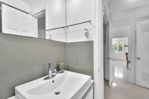 uma casa de banho branca com um lavatório e um espelho em Seaheights Villa em Miami Beach