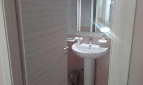 a bathroom with a white sink and a mirror at HOTEL DED 1 in Parma