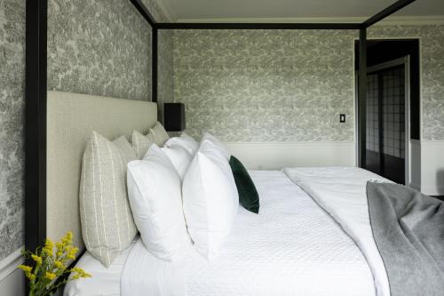 a bedroom with a white bed with white pillows at The Litchfield Inn in Litchfield