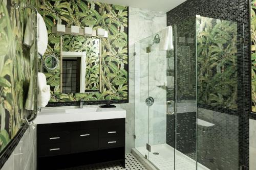 a bathroom with a shower and a sink and a mirror at The Litchfield Inn in Litchfield