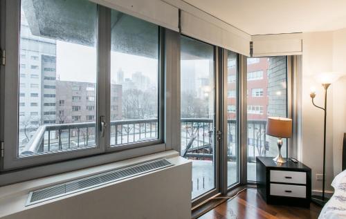 a bedroom with large windows with a view of a city at 3 BR with Splendid River views in New York