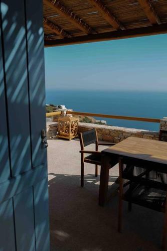 a table and chairs on a patio with the ocean at Blue Calm Luxury Villa in Sifnos in Artemonas