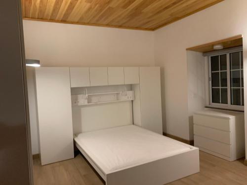 a small bedroom with a white bed and a window at Fazenda Apartments - Apartment 3 in Lajes das Flores