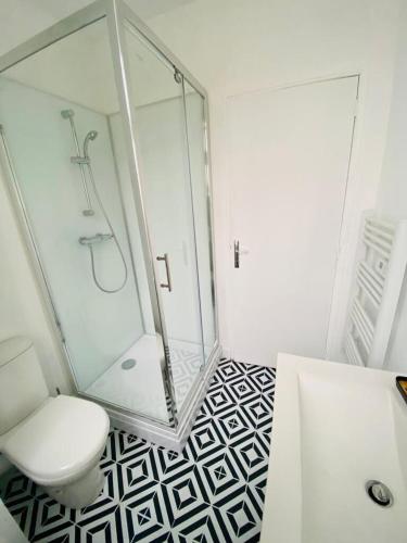 a bathroom with a glass shower and a toilet at Au coeur de ville in Laval