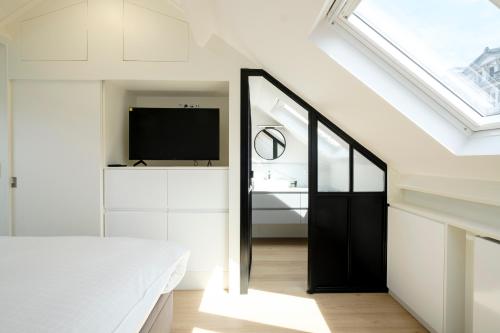 1 dormitorio con 1 cama y tragaluz en The Rose Flats en Bruselas