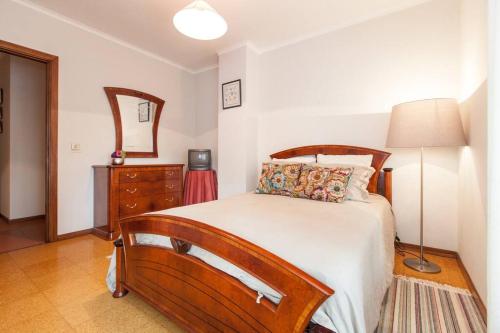 1 dormitorio con cama, tocador y espejo en Flat at the beach, en Viana do Castelo