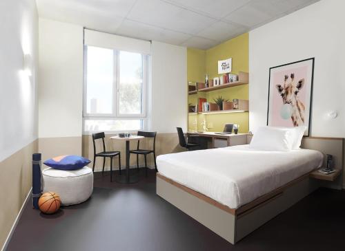 a bedroom with a bed and a desk and a table at Giovenale Milan Navigli - Modern rooms and open spaces in the heart of the city in Milan