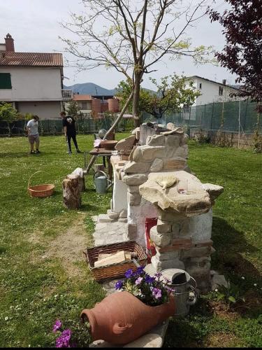 a stone fireplace with flowers in a yard at Villa La Pineta in Umbertide