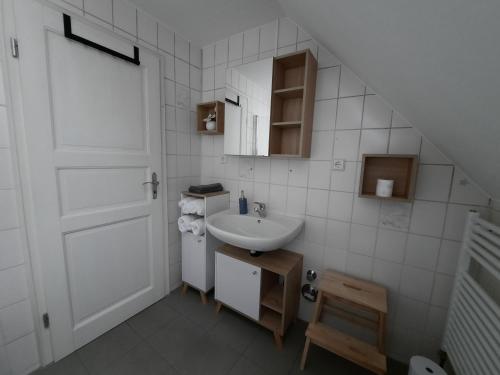 Baño blanco con lavabo y puerta en Wohnung in Bad Lippspringe, en Bad Lippspringe