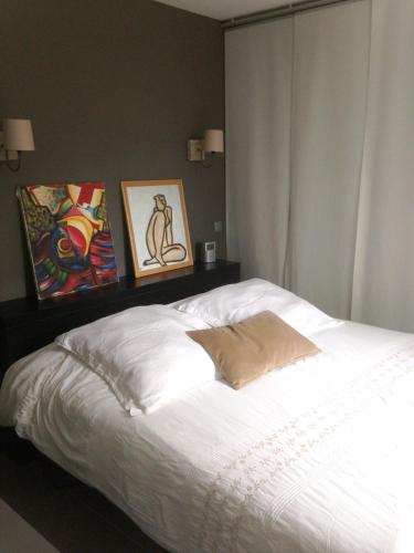 - une chambre avec un lit blanc orné de peintures murales dans l'établissement Villa charmante à Eyragues avec piscine privée, à Eyragues