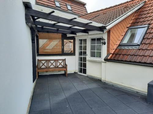 a pergola on the side of a house with a bench at Wohnung in Bad Lippspringe in Bad Lippspringe
