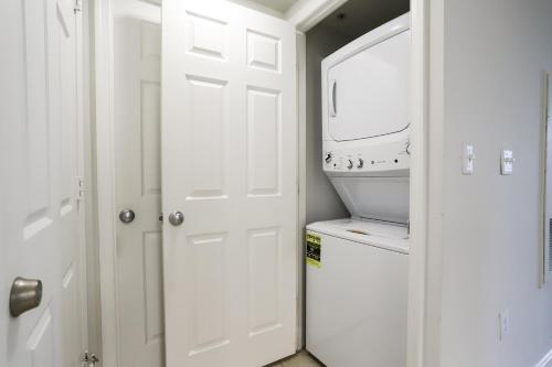 ein Badezimmer mit einer weißen Tür, einer Waschmaschine und einem Trockner in der Unterkunft Amazing 2 Bedrooms Condo at Ballston with gym in Arlington