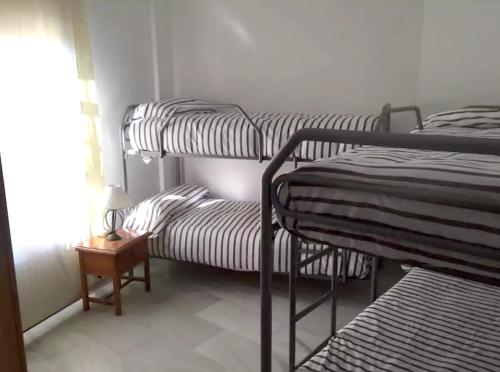 Cette chambre comprend 2 lits superposés et une table. dans l'établissement 3 bedrooms house with city view at Cordoba, à Cordoue