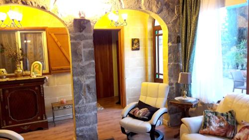 a living room with two chairs and a mirror at One bedroom house with jacuzzi enclosed garden and wifi at Siggiewi 2 km away from the beach in Siġġiewi