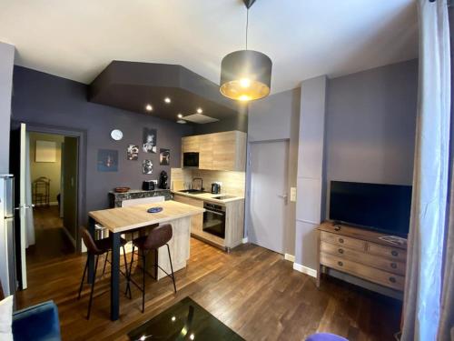 une cuisine avec une table et une cuisine avec une cuisinière dans l'établissement Velvet - Centre Historique - Parking Hôtel Dieu, à Bourges