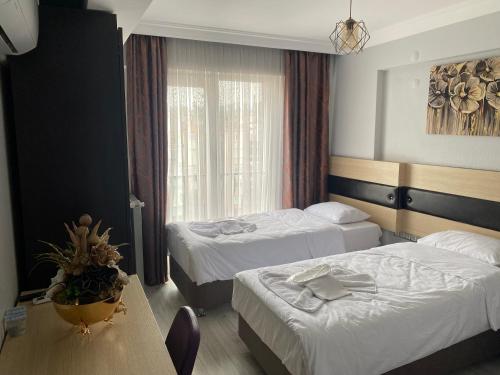 Habitación de hotel con 2 camas y mesa en Ece Han Butik Otel en Atakum