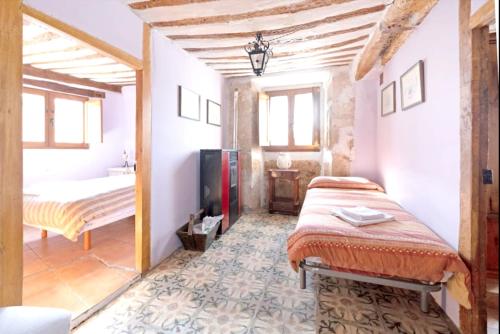 Un dormitorio con una cama y un televisor en una habitación. en Spacious House in Llano de Bureba with Fireplace & Mountain View, en Llano de Bureba