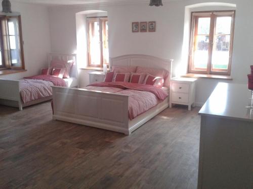 a bedroom with two beds and two windows at Penzion a hospoda Na statku in Hluboká nad Vltavou