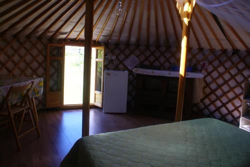 a room with a bed and a refrigerator in a yurt at Yurta Flora in Torino di Sangro