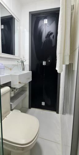 a bathroom with a toilet and a glass shower door at Ap Carioca in Rio de Janeiro