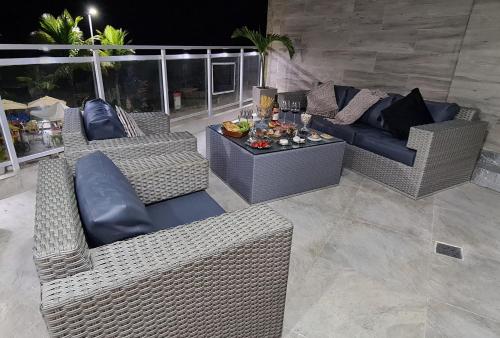 a patio with wicker couches and a table with food on it at Ap Carioca in Rio de Janeiro