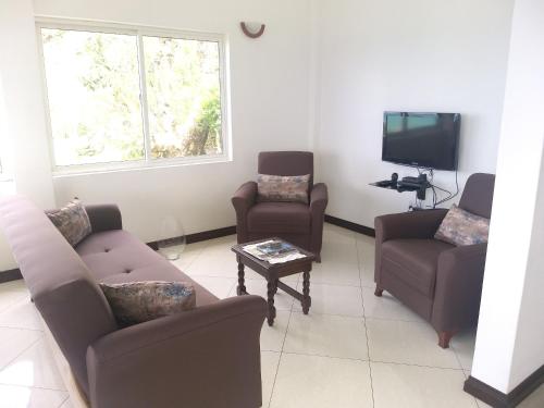 a living room with a couch and chairs and a tv at Elegant Villa with Sea View in Victoria in Victoria