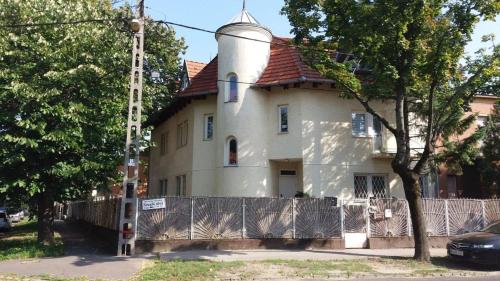 a white house with a tower on top of it at Remo's Villa by Zugló in Budapest