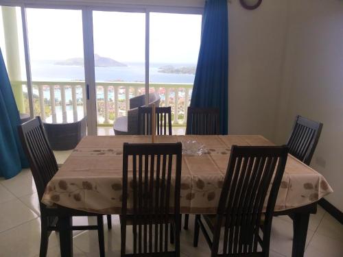 a dining room table and chairs with a view of the ocean at 2 bedrooms villa with sea view enclosed garden and wifi at Victoria Zig Zag Ward 6 km away from the beach in Victoria