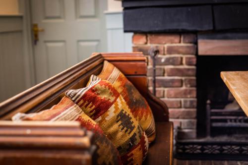 a pile of pillows sitting in front of a fireplace at The Cricketers Inn in Petersfield