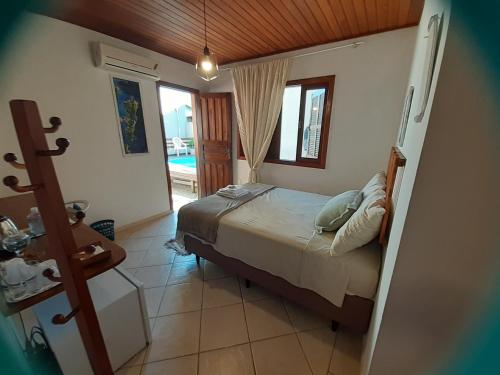 um quarto com uma cama e uma porta para uma piscina em Sol poente em Florianópolis