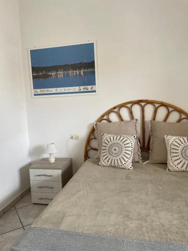una camera da letto con letto, testiera e cuscini in legno di PIACENTINI - Apulia Home a San Pietro in Bevagna