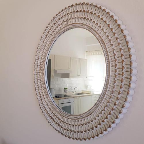 a mirror hanging on a wall in a kitchen at Katy's Luxury Apartments in Kavros