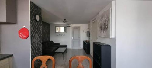 - un petit salon avec deux chaises et une table dans l'établissement L'indéniable, à Sète