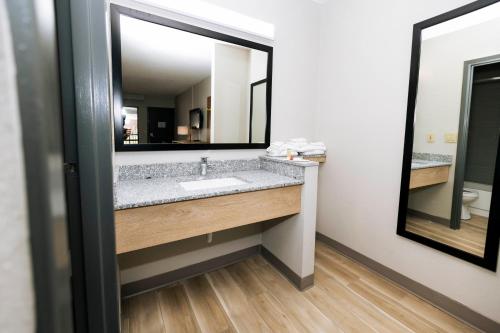 a bathroom with a sink and a mirror at Days Inn by Wyndham Cincinnati East in Cherry Grove
