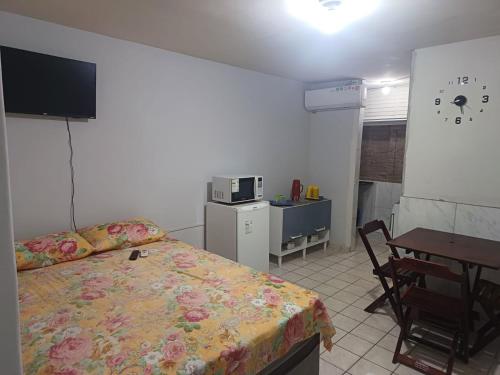 um quarto com uma cama, uma mesa e uma secretária em AP CENTRAL em Campina Grande