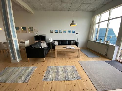 uma sala de estar com um sofá e uma mesa em Skærven Beachfront Apartments and Cottage em Nyborg