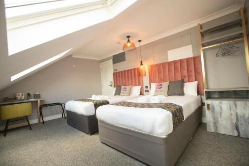 una camera d'albergo con due letti e una scala di Comfotel GRN a Londra