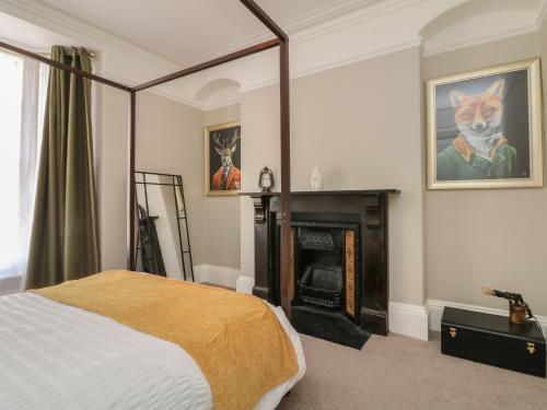 a bedroom with a bed and a fireplace at Myrtle House in Ilfracombe