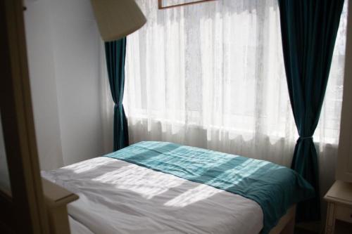 a bed sitting in front of a window at Blue Joy Bukovina Aparthotel in Suceava