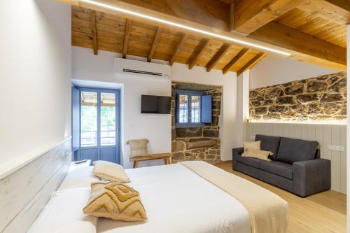 1 dormitorio con 1 cama grande y 1 sofá en Alojamiento Turístico Caxide Parada de Sil Ribeira Sacra, en Parada del Sil