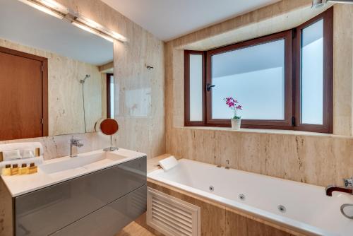 a bathroom with a tub and a sink and a window at VACATION MARBELLA I 300 SQM Penthouse, Private Swimming pool, BBQ, WiFi in Marbella