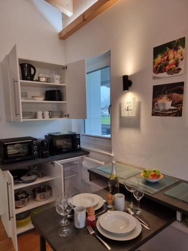 a kitchen with a table with plates on it at Golf & Ski Appartements Mittersill Trausmuth Monika inkl Sommercard - Golfplatz 500 m entfernt, inkl Waschmaschine, Trockner in Mittersill